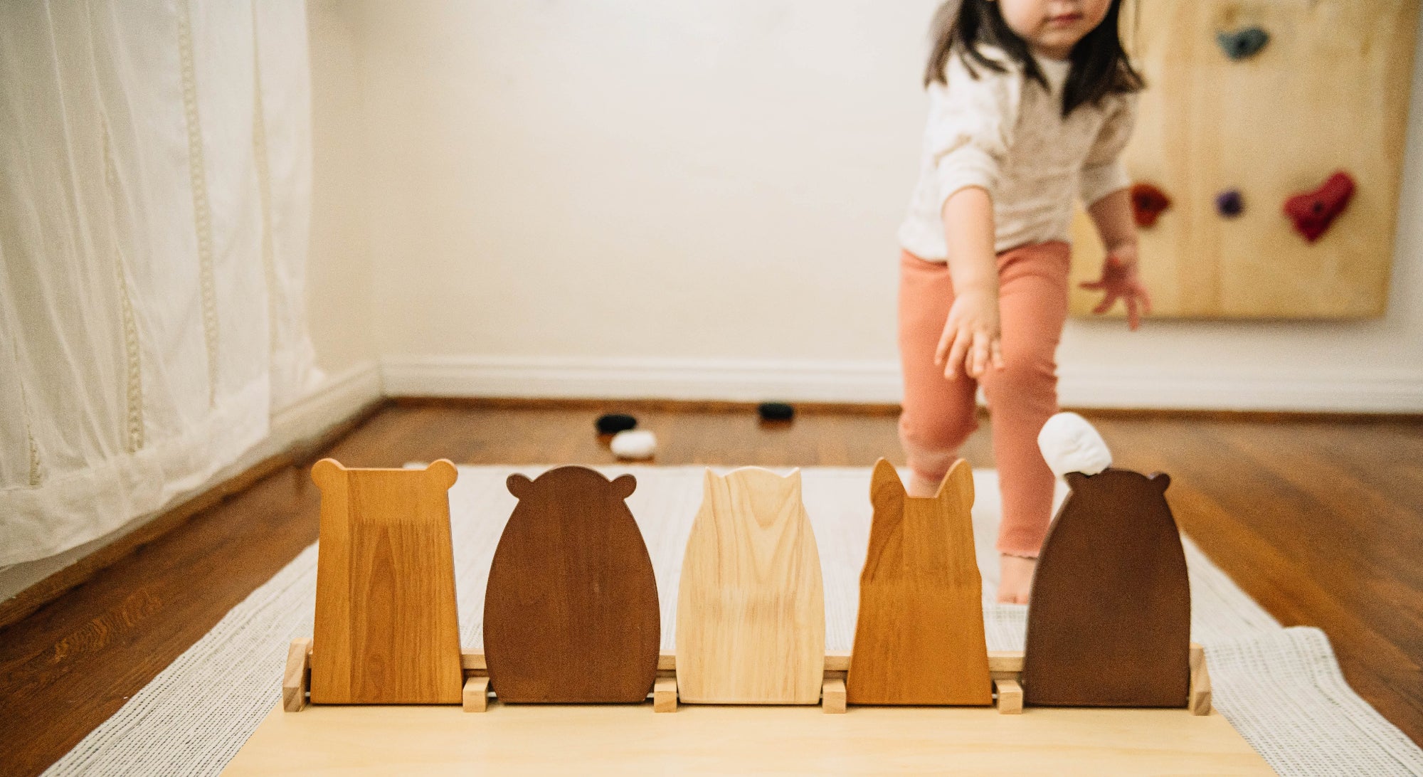 Child playing with a wooden toy on a rug