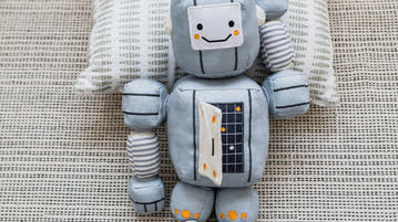 Wonder & Wise Tot Bot posing on a pillow.