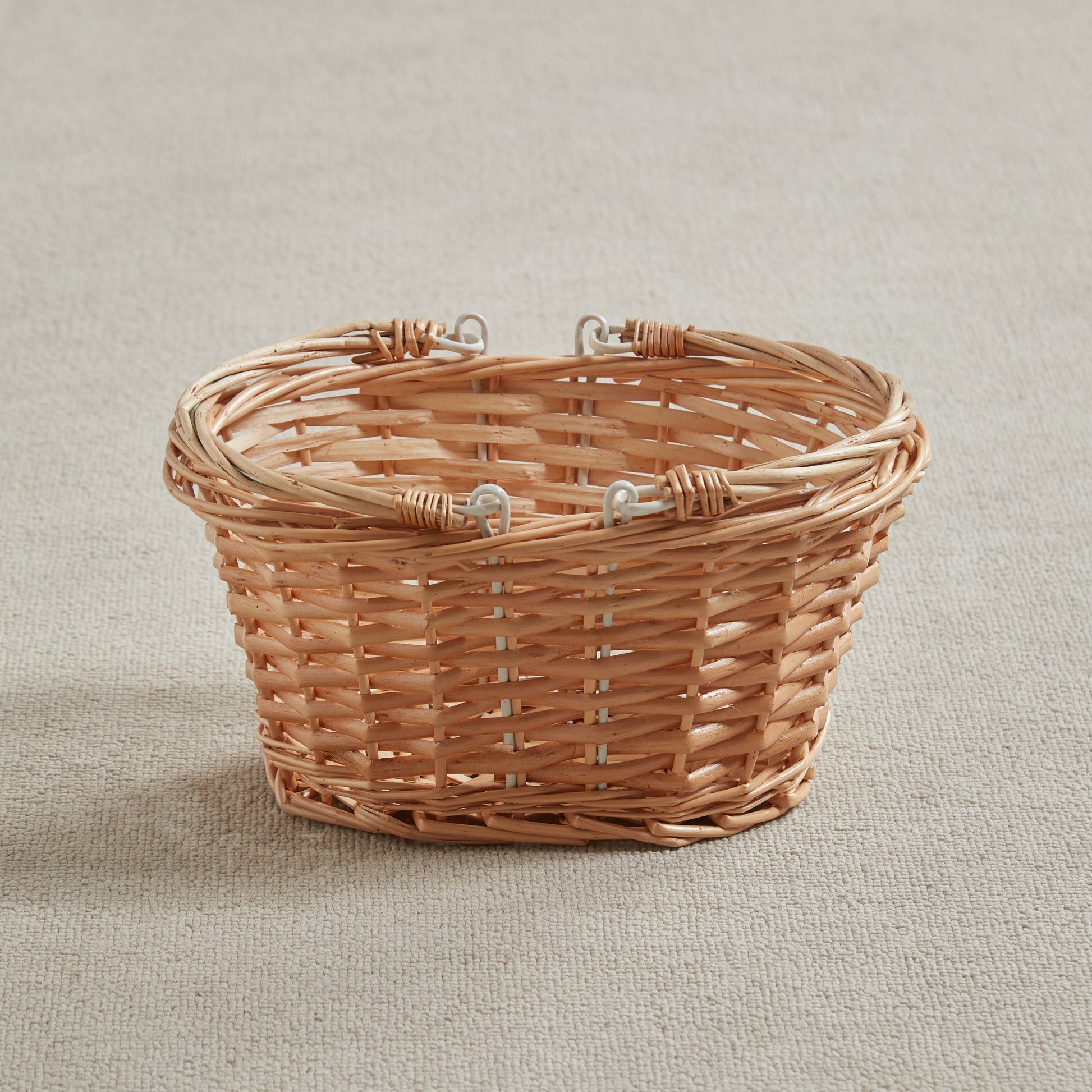 Sturdy wicker basket on a beige fabric background