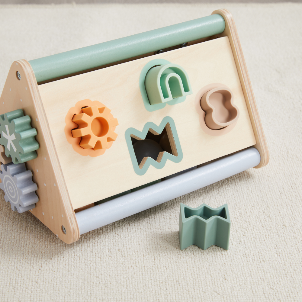 Wooden activity triangle with colorful shape sorters including gear, arch, wavy and butterfly cutouts