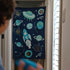 Space-themed doorway bean bag toss game with planets, rocket, and clouds on dark blue fabric
