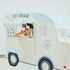 Child playing in cream and blue ice cream truck playhouse with striped awning