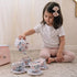 Girl playing with plush tea set for toddlers in pink and blue floral pattern
