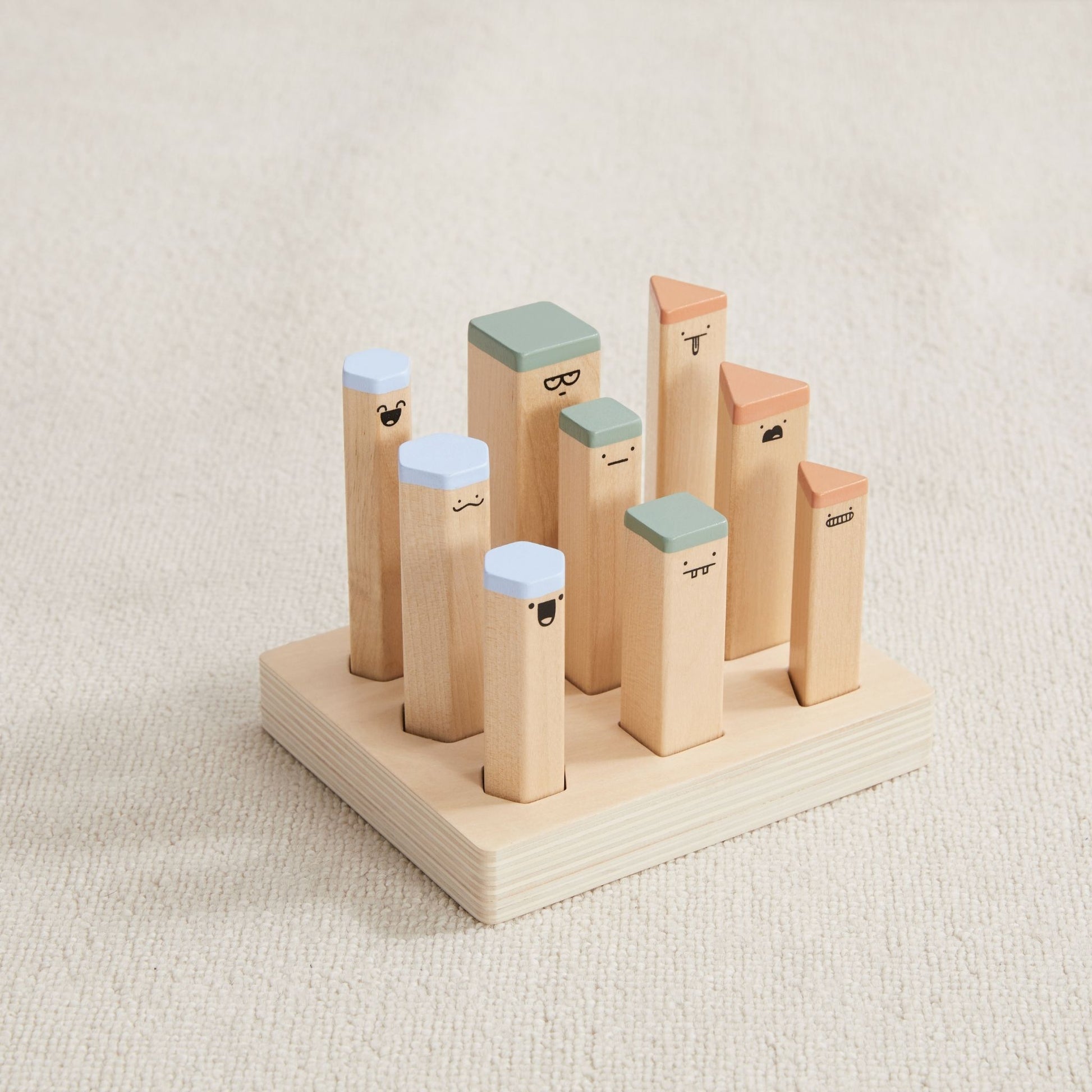 Wooden baby gift set with 9 colorful character blocks featuring painted faces and colored caps on a natural base