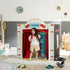Child playing inside a theater playhouse set up in a room.