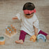 Baby girl playing with wooden blocks and colorful stacking toys on carpet