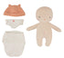 Cookie doll in a white diaper and peach cap next to its swaddle.