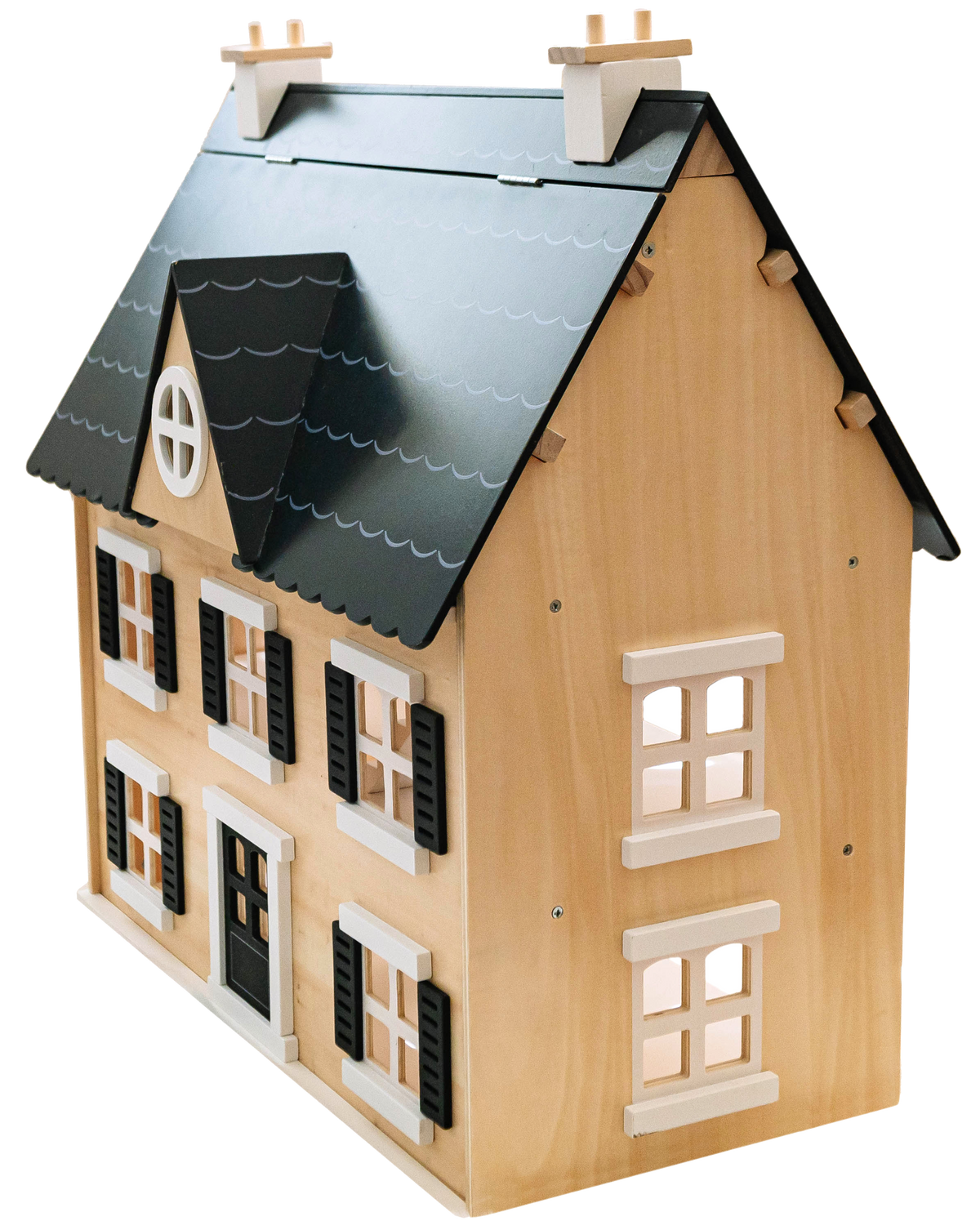 Wooden Dollhouse at an angle on white, showing its black scalloped roof, dormer window, chimneys and shuttered windows