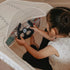 Child sitting in the Gone Flying Airplane holding the felt steering yoke