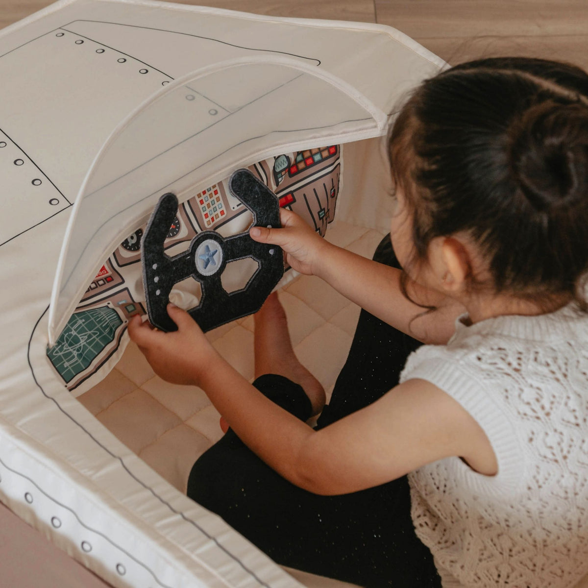 Child sitting in the Gone Flying Airplane holding the felt steering yoke