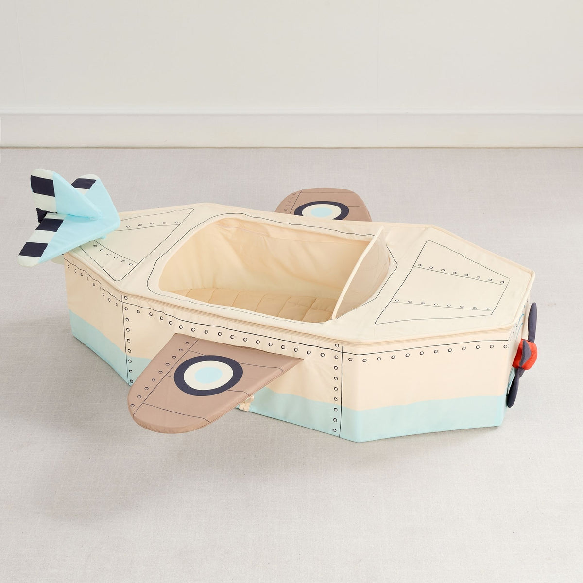 Gone Flying Airplane cream canvas play nook with tan wings, light blue tail and a cushioned cockpit