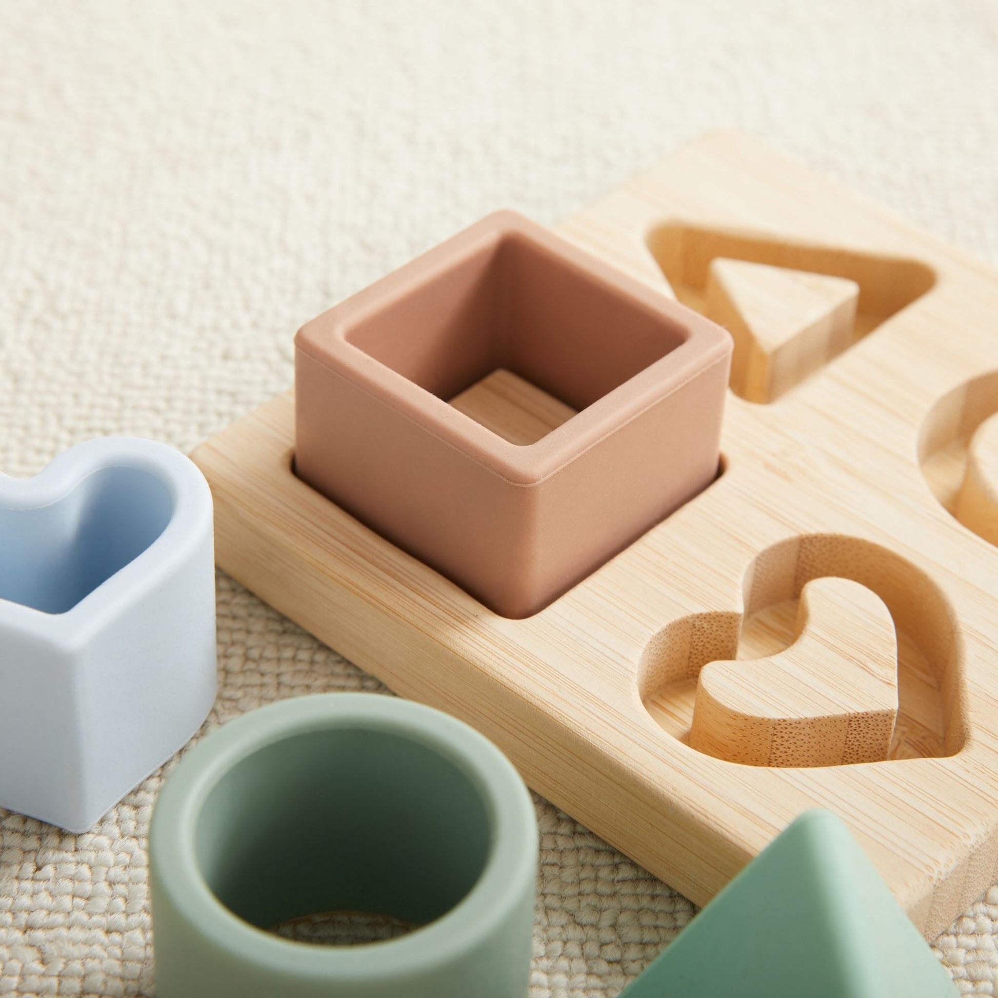 Colorful silicone toys and wooden shape sorter from a baby gift set for 6-9 months