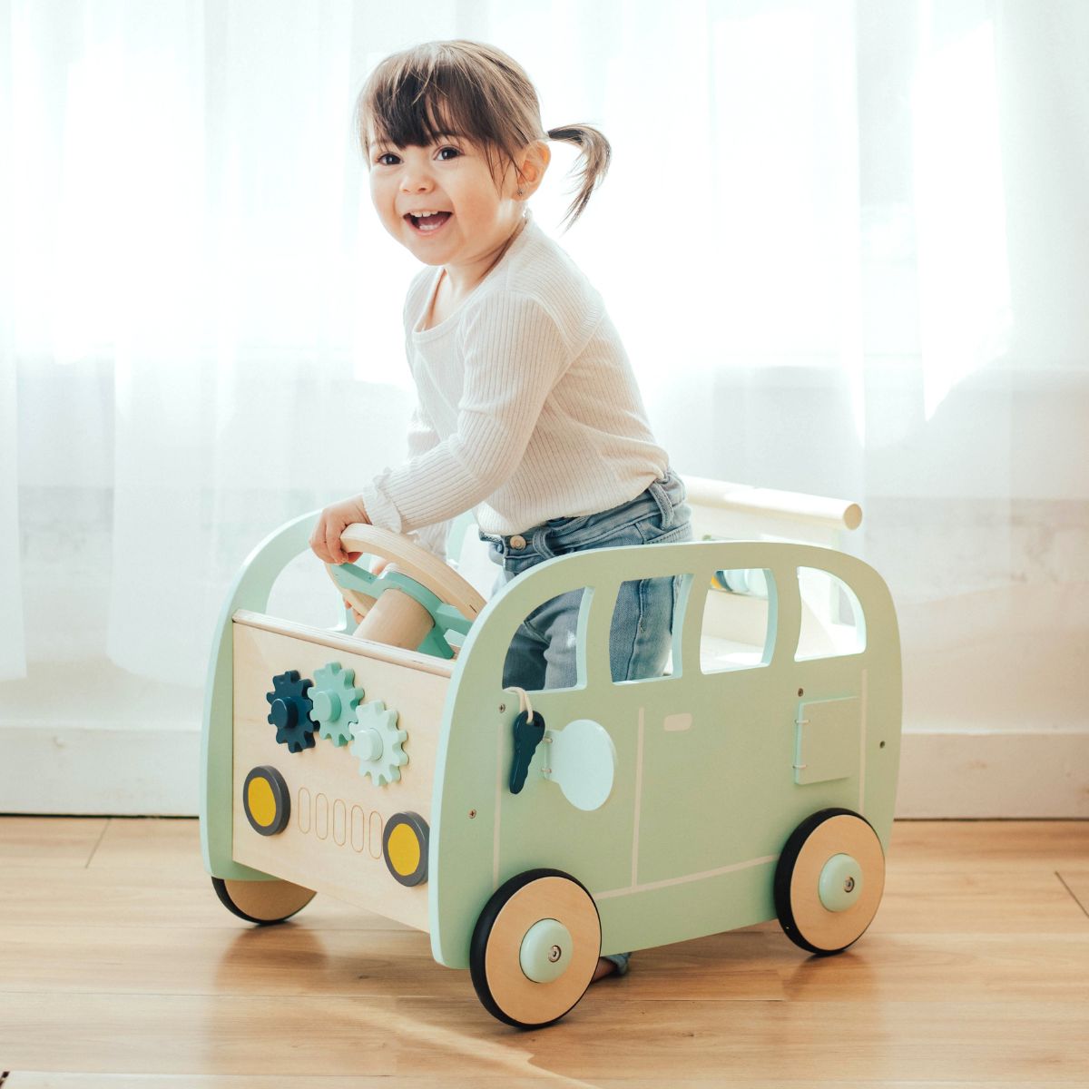 toddler having fun in an activity walker and push car