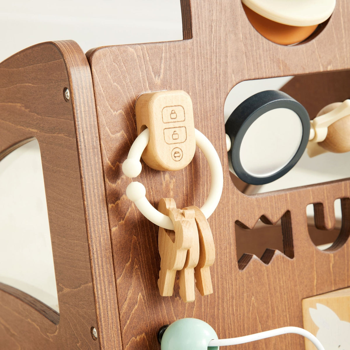 Close-up of the wooden key fob and keys on a ring attached to the Waldo Activity Walker panel