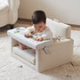 Baby seated in the Rolling Along Square Chair playing with the activity tray on a shag rug
