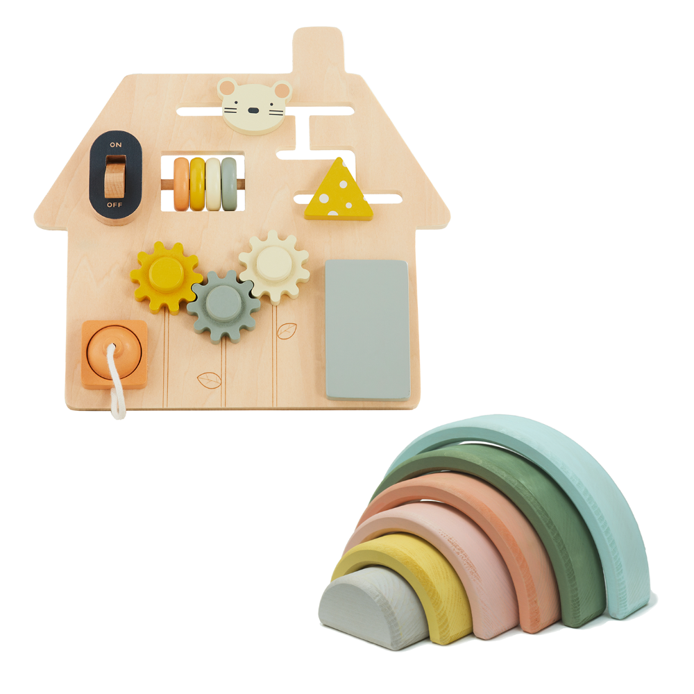 Wooden toy house with various educational elements and a stack of colorful wooden rings on a white background.