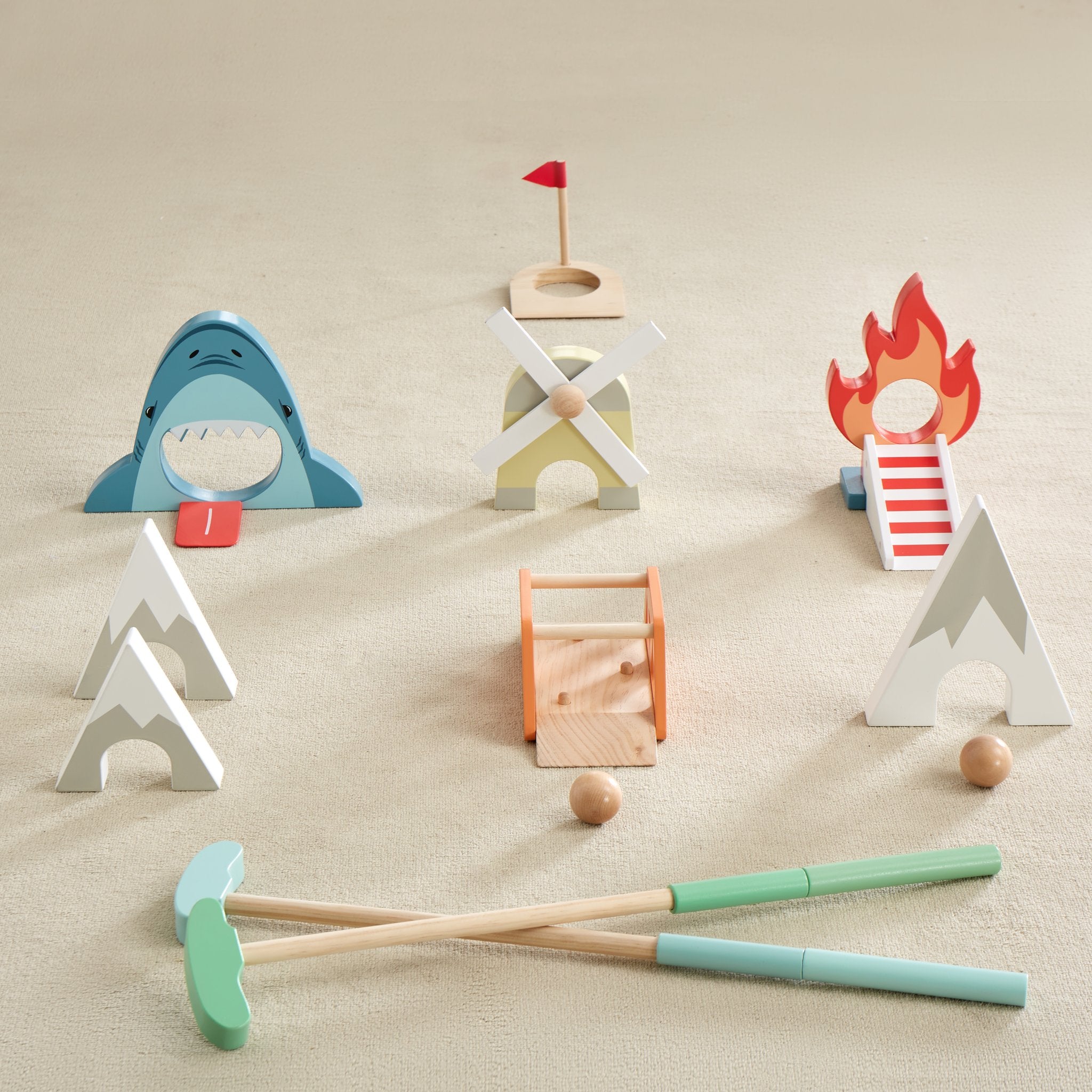 Putt Putt Golf set on carpet with shark, windmill, flame ramp, mountains, bridge, flag hole, balls and two clubs