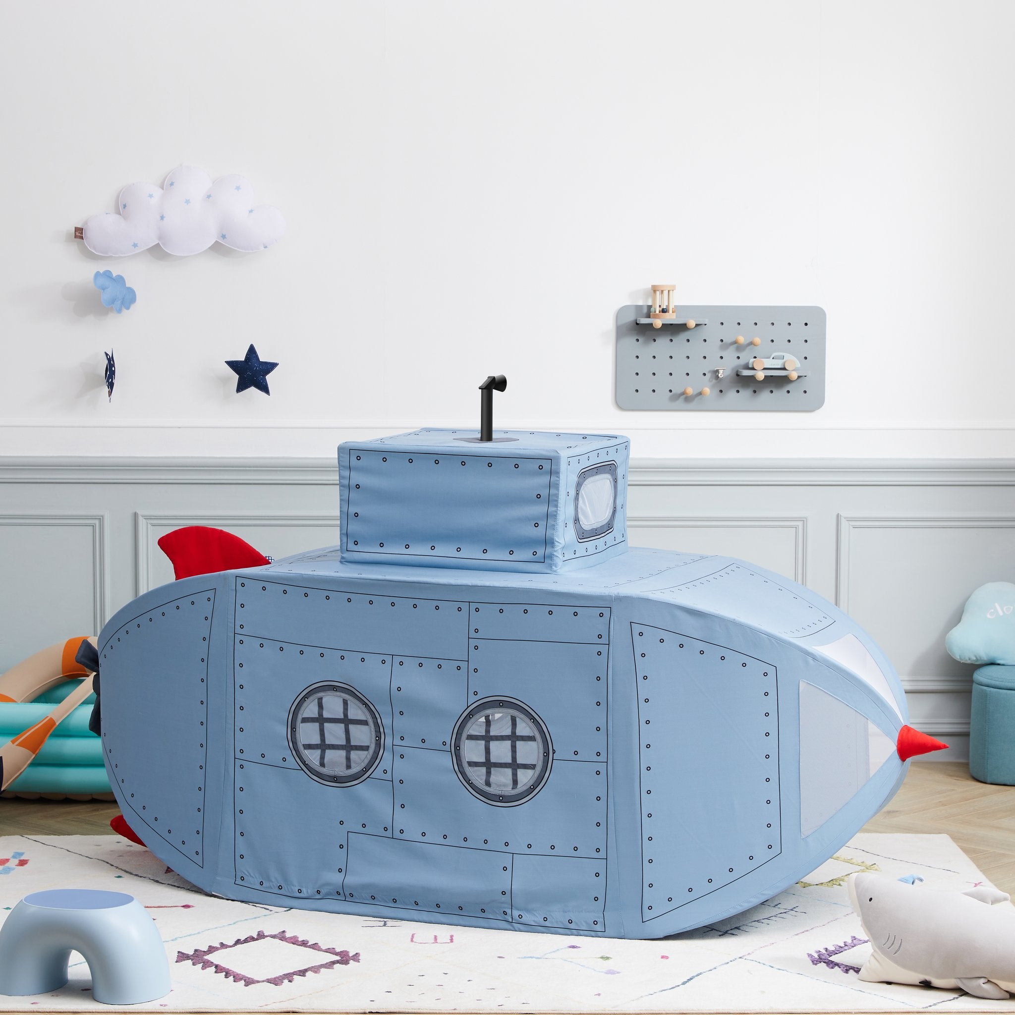 Submarine Playhome on a cream rug in a playroom, cloud and star wall decor behind, periscope pointing up