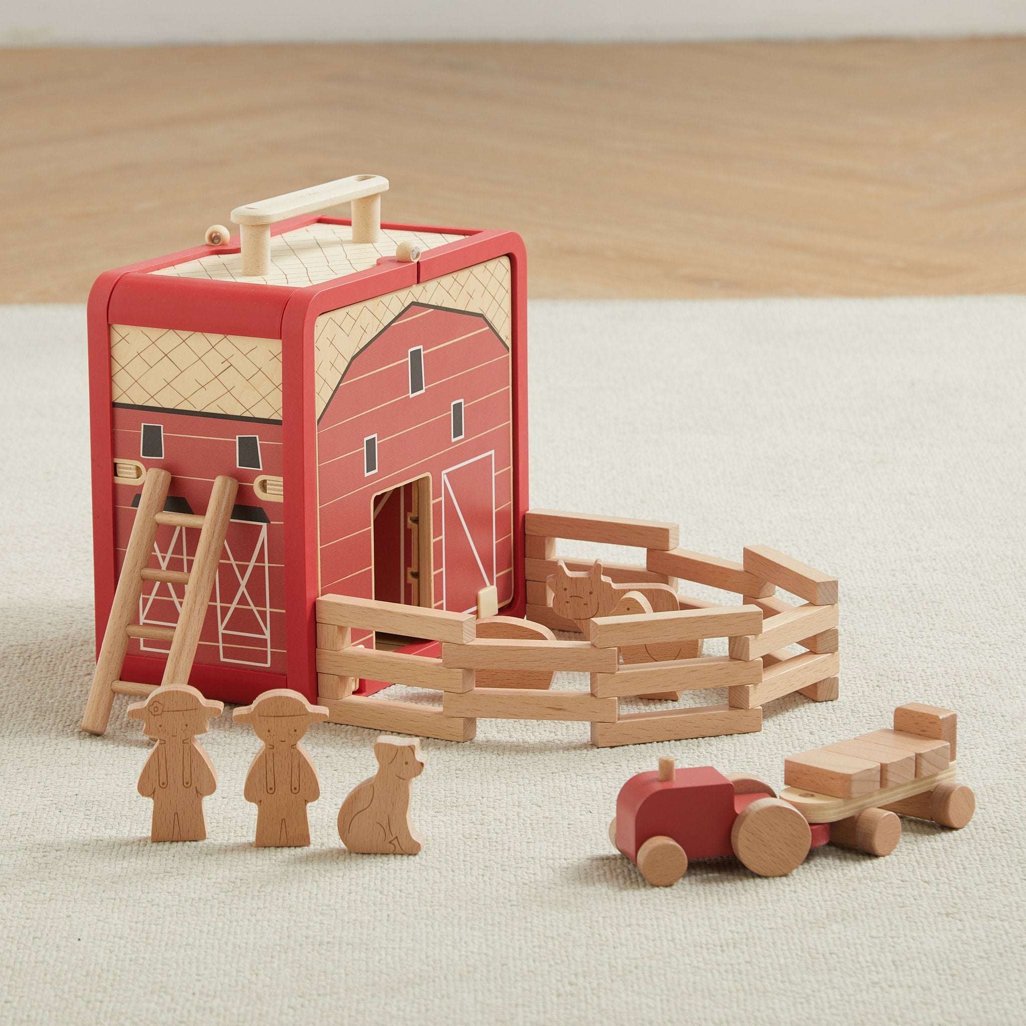 Take with Me Farm set on a cream rug with the barn, fence pen, farmers, dog and tractor