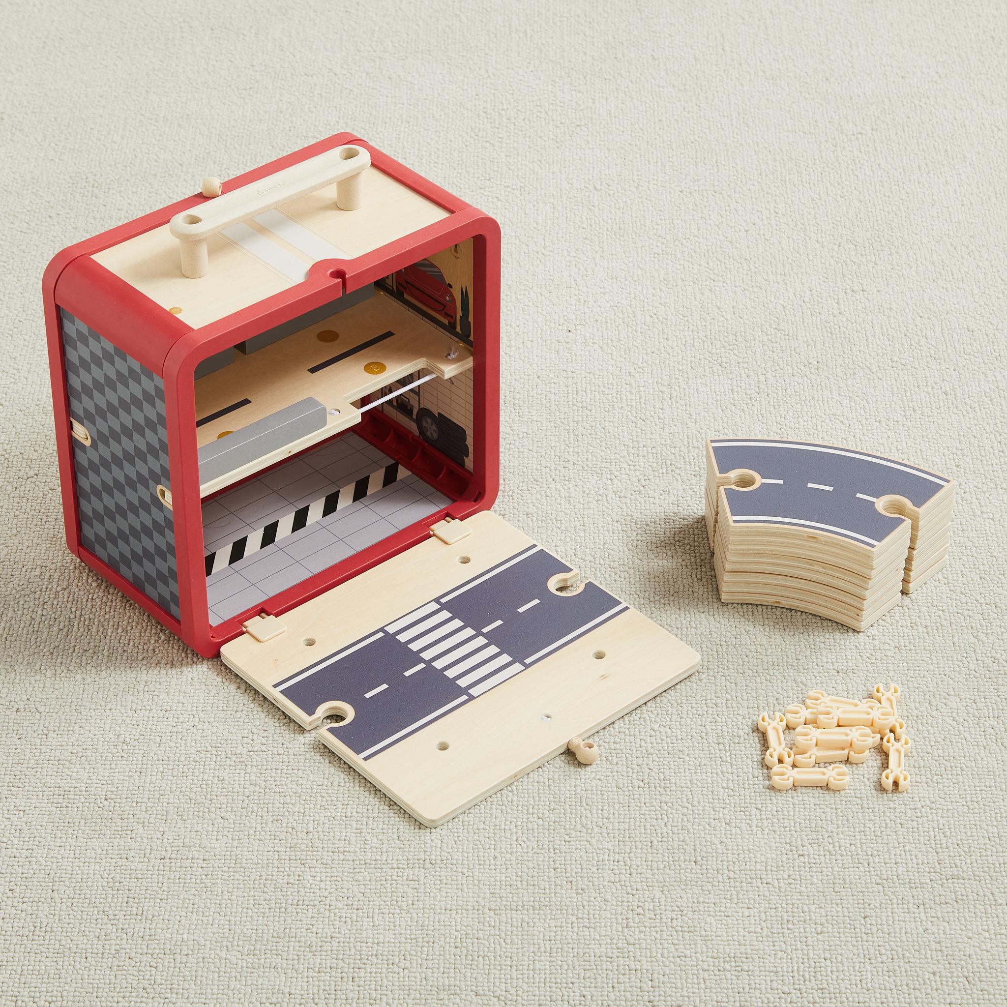 Take With Me Garage case open to show interior levels, with stacked road pieces and connectors beside it