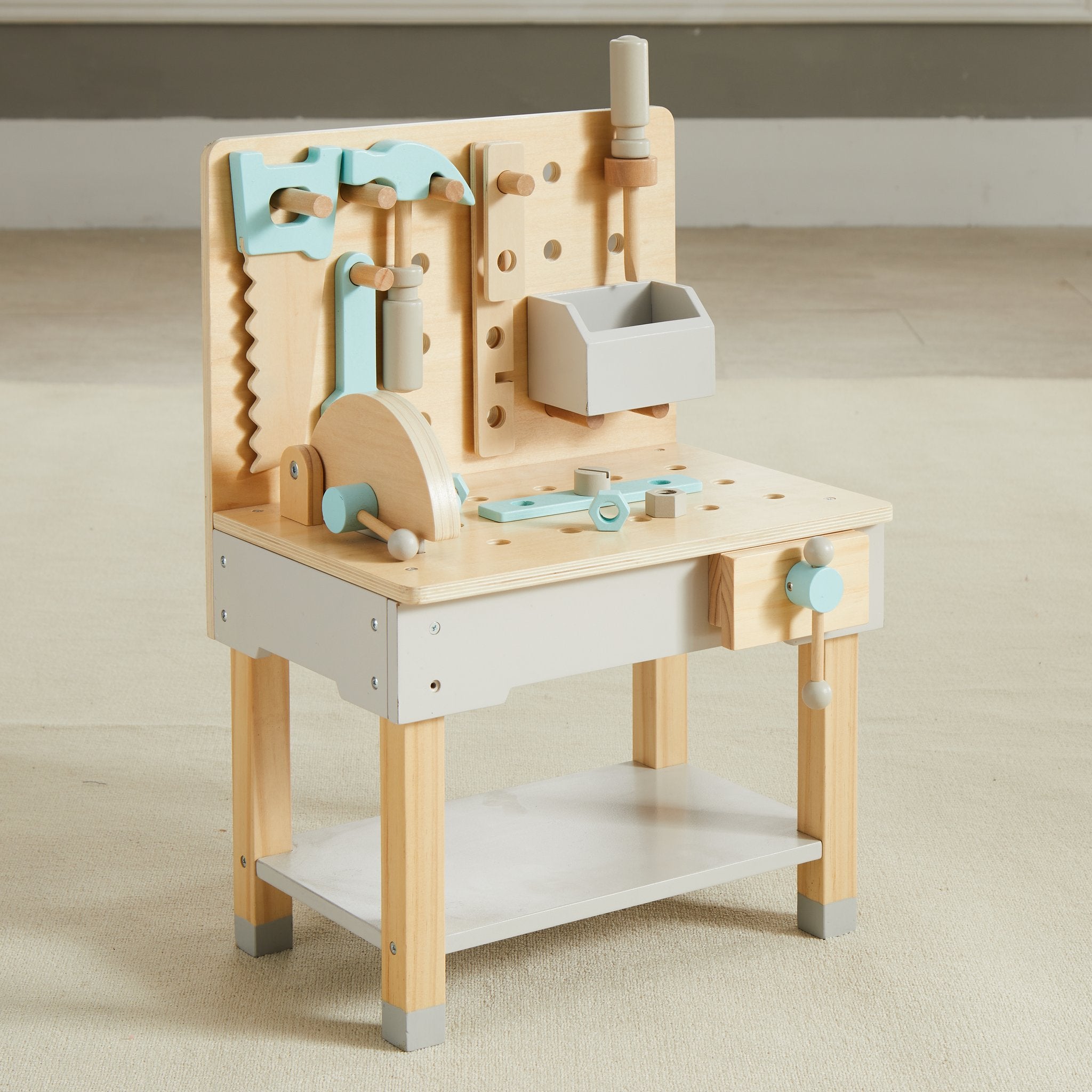 Little Builder Workbench angled on a cream rug showing the circular saw, vise and tool bin
