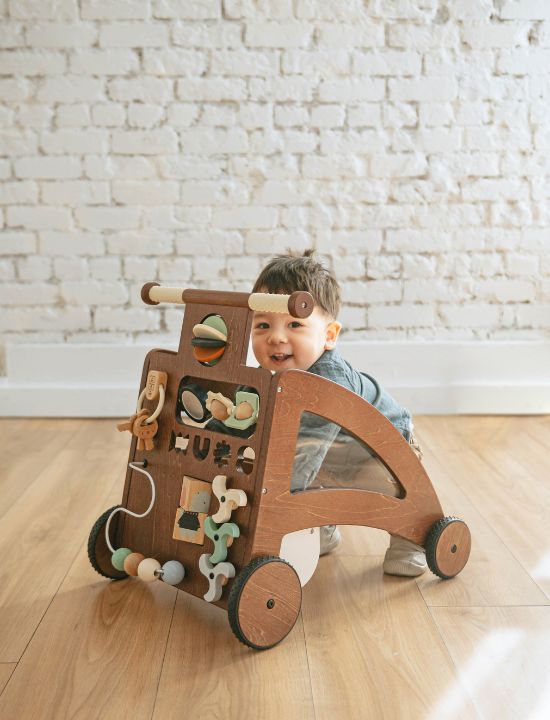 toddler playing with our wooden activity walker